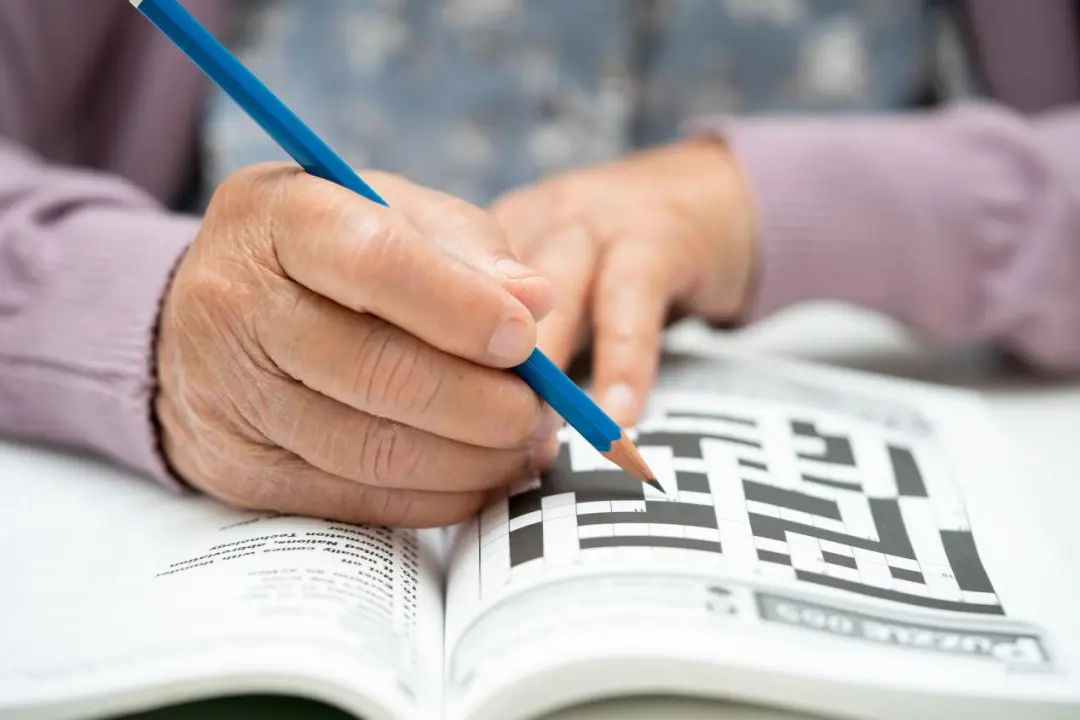 An older adult keeping the mind active with a crossword puzzle