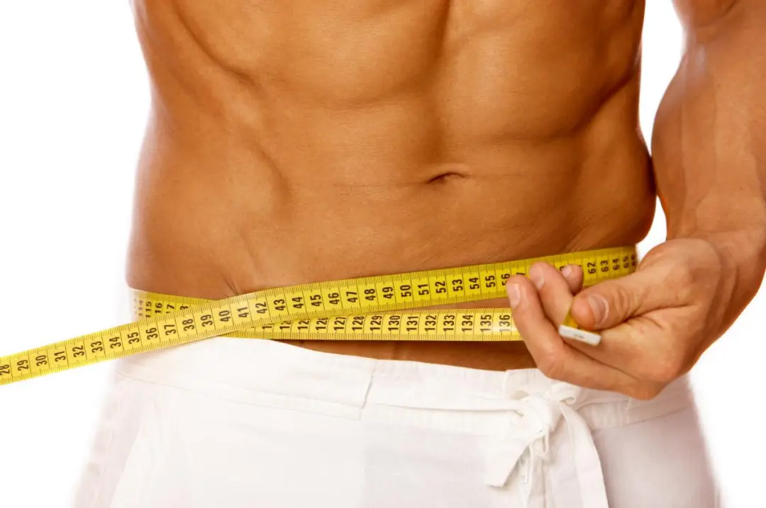 Fit torso with measuring tape — sustainable fat loss preserves muscle and improves metabolic markers
